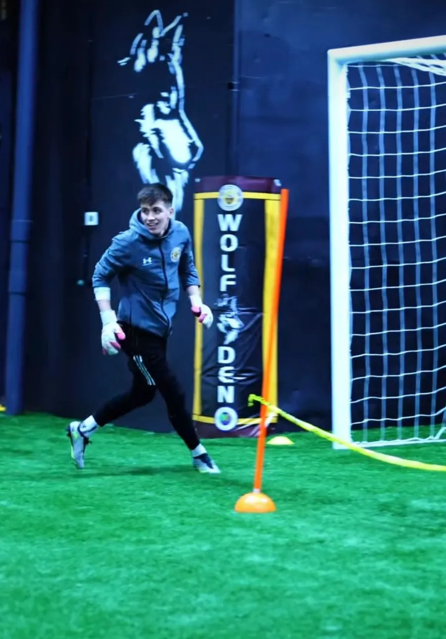 A goalkeeper working through a drill beside the net