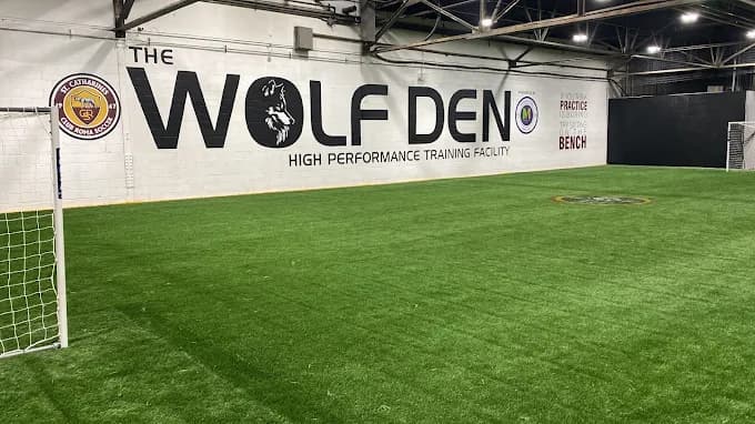 The indoor pitch and goal in front of the Wolf Den high performance training facility wall