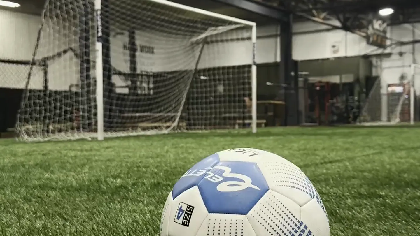 Players training on the indoor turf beneath the Wolf Den wall mural