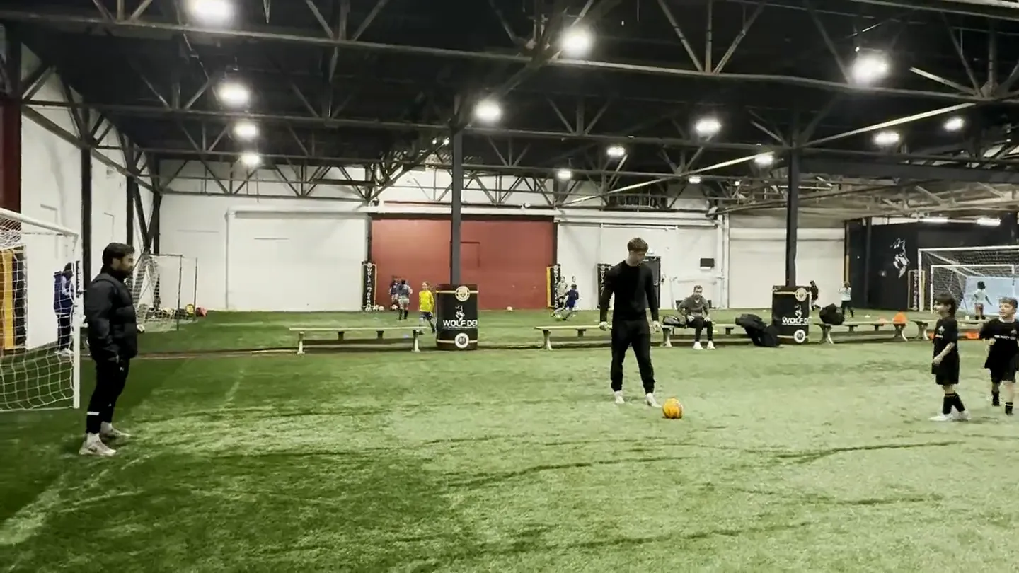 Players training on the indoor turf beneath the Wolf Den wall mural